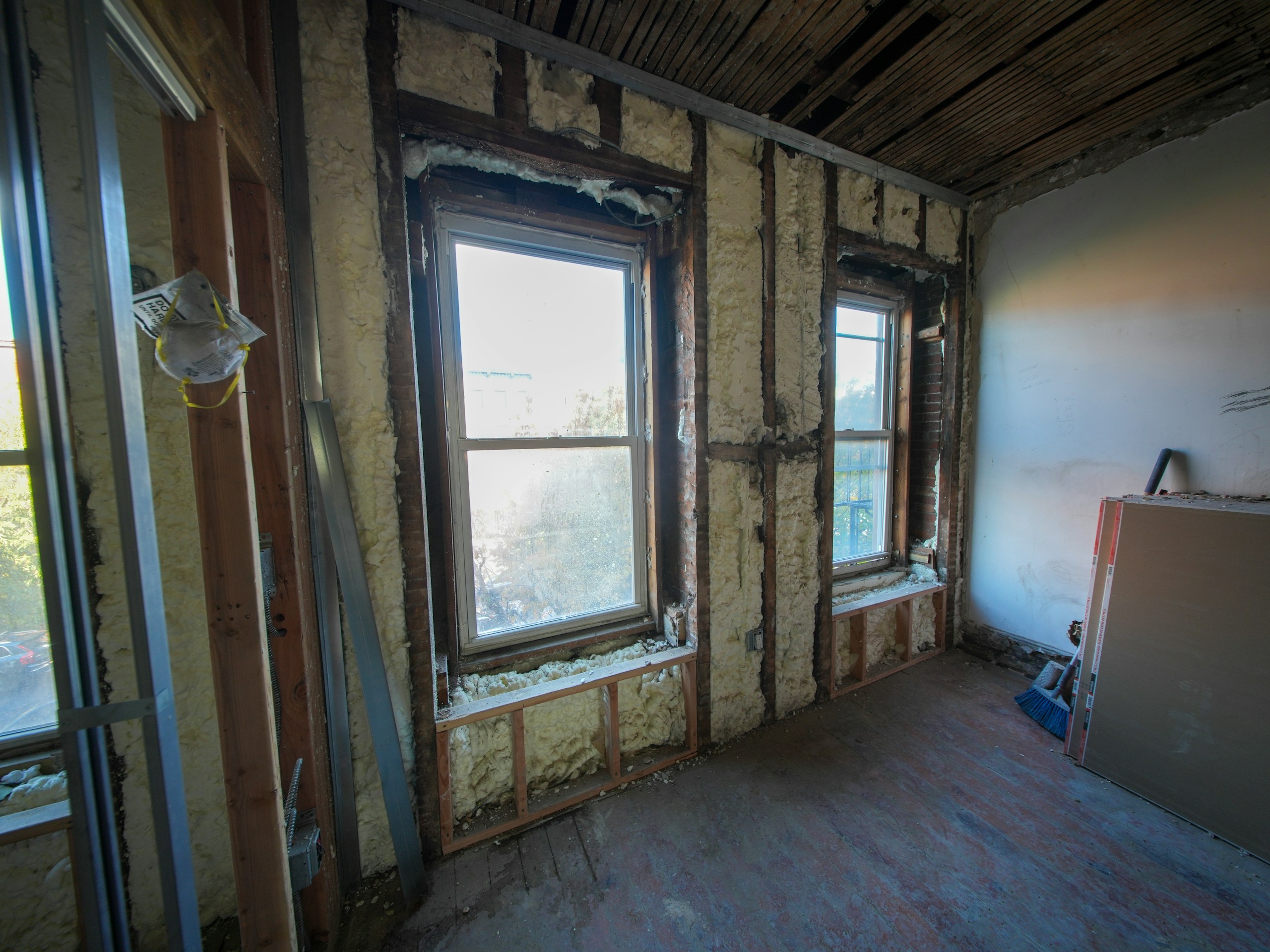 A three-story brownstone stands in mid-transformation, captured at the raw and honest “before” stage of a full interior renovation. These images document a moment that usually disappears once the walls are closed and the finishes are installed — exposed framing, stripped ceilings, rough staircases, and open corridors that reveal the building’s original structure and hidden history. Light spills in through skylights and tall windows, cutting through layers of dust and unfinished surfaces, creating a quiet contrast between decay and renewal. The space feels both industrial and intimate: narrow